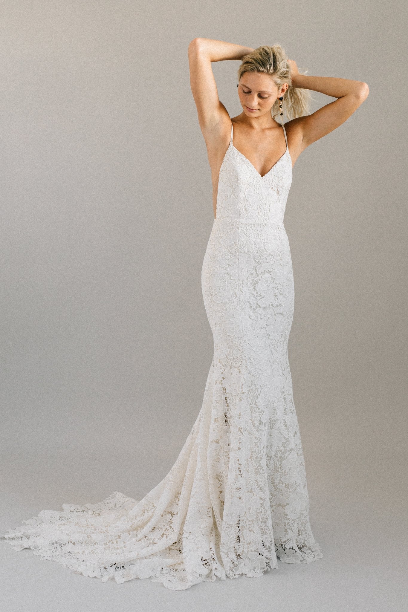 Boho backless wedding dress with bold floral lace, spaghetti straps, and a long train