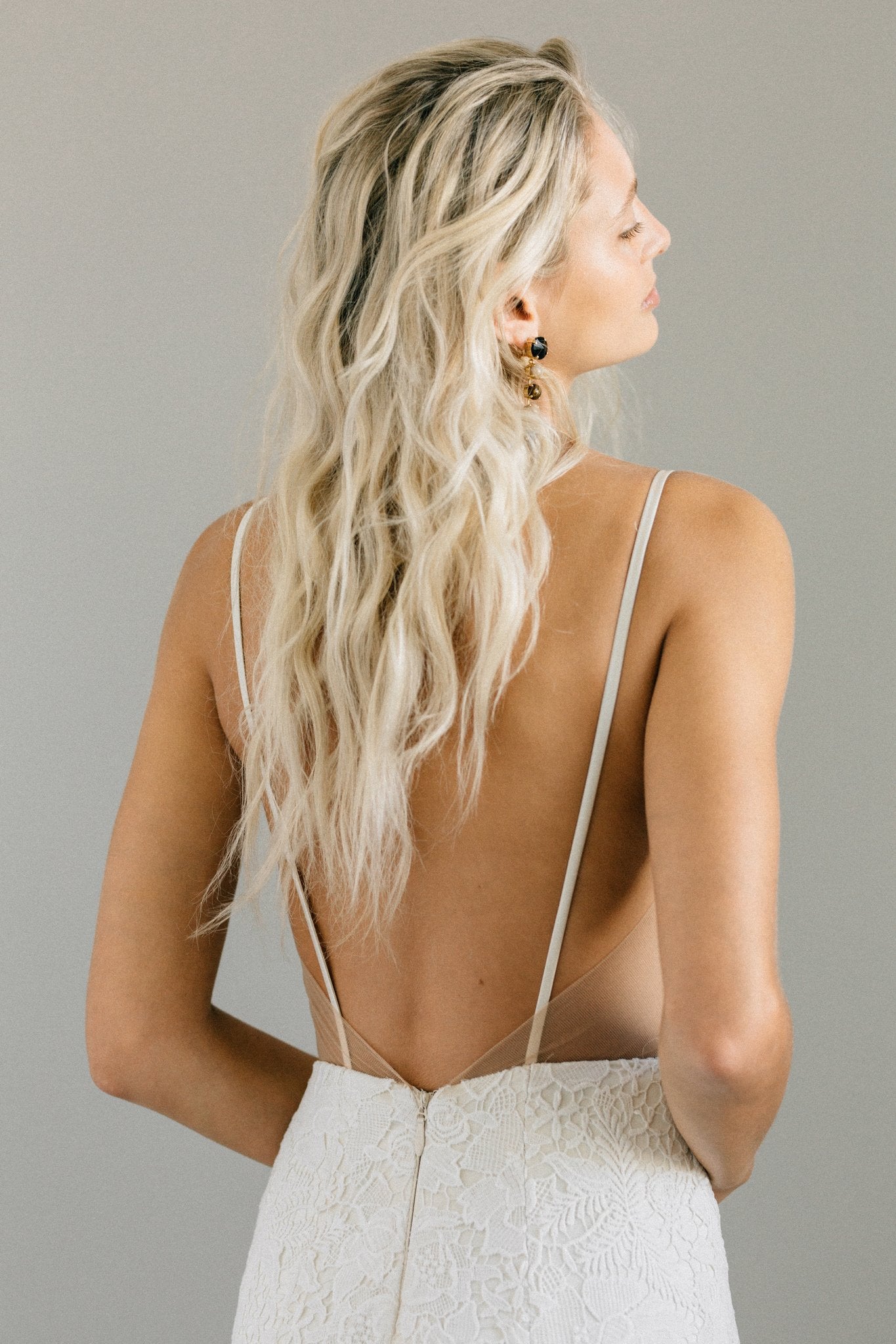 Boho backless wedding dress with bold floral lace, spaghetti straps, and a long train
