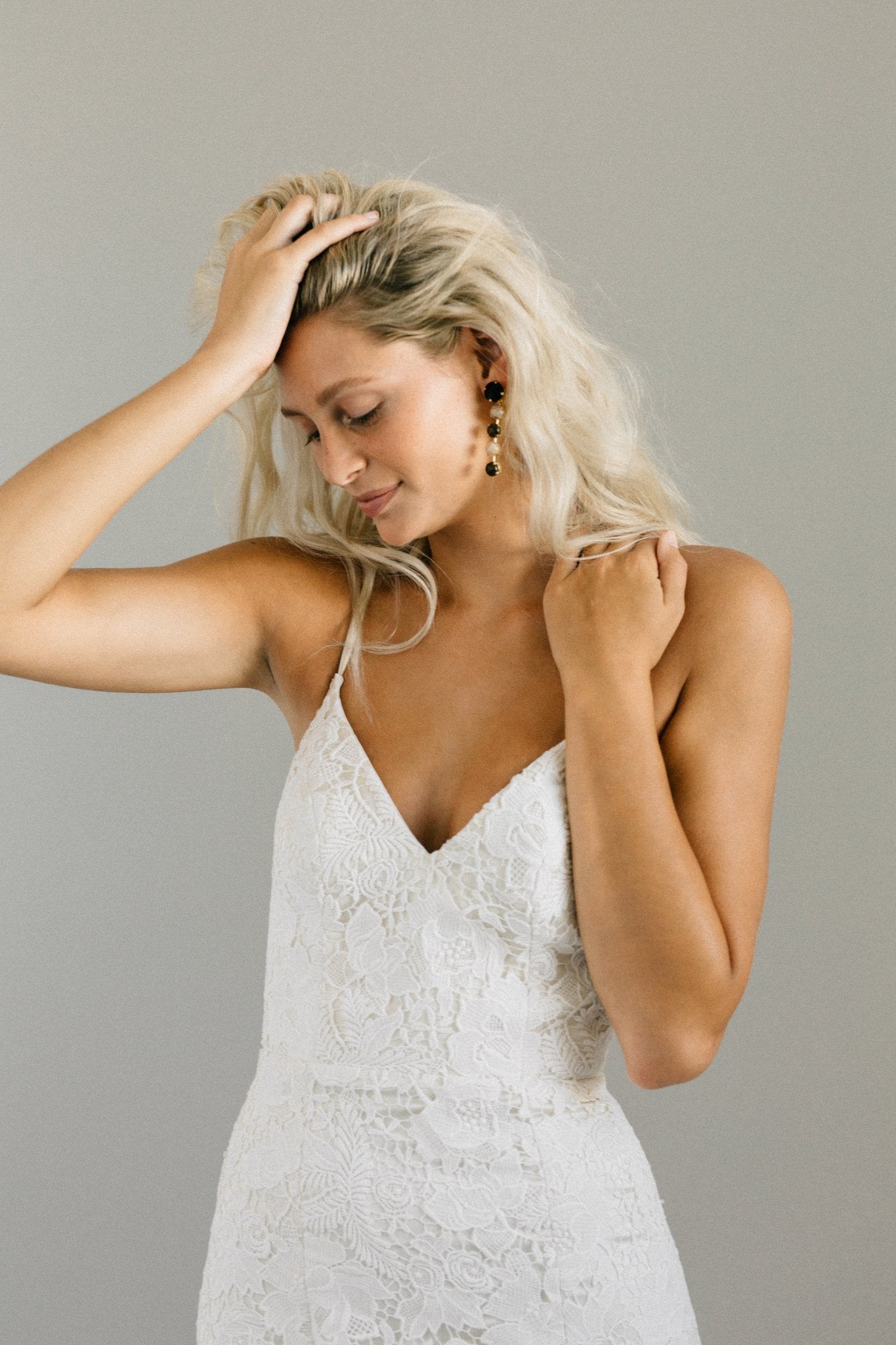 Boho backless wedding dress with bold floral lace, spaghetti straps, and a long train
