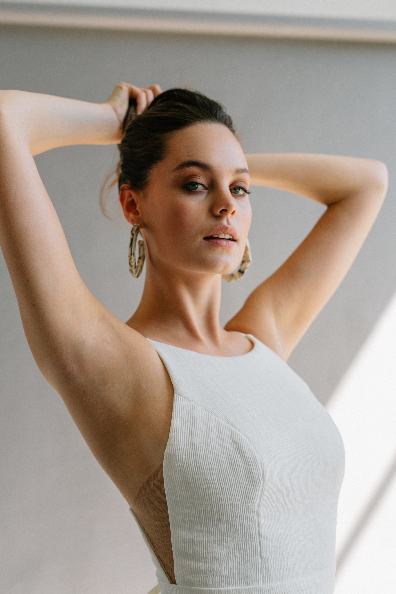 A high neck wedding dress with a low back, built-in bow, and a lace mermaid skirt with a hidden slit