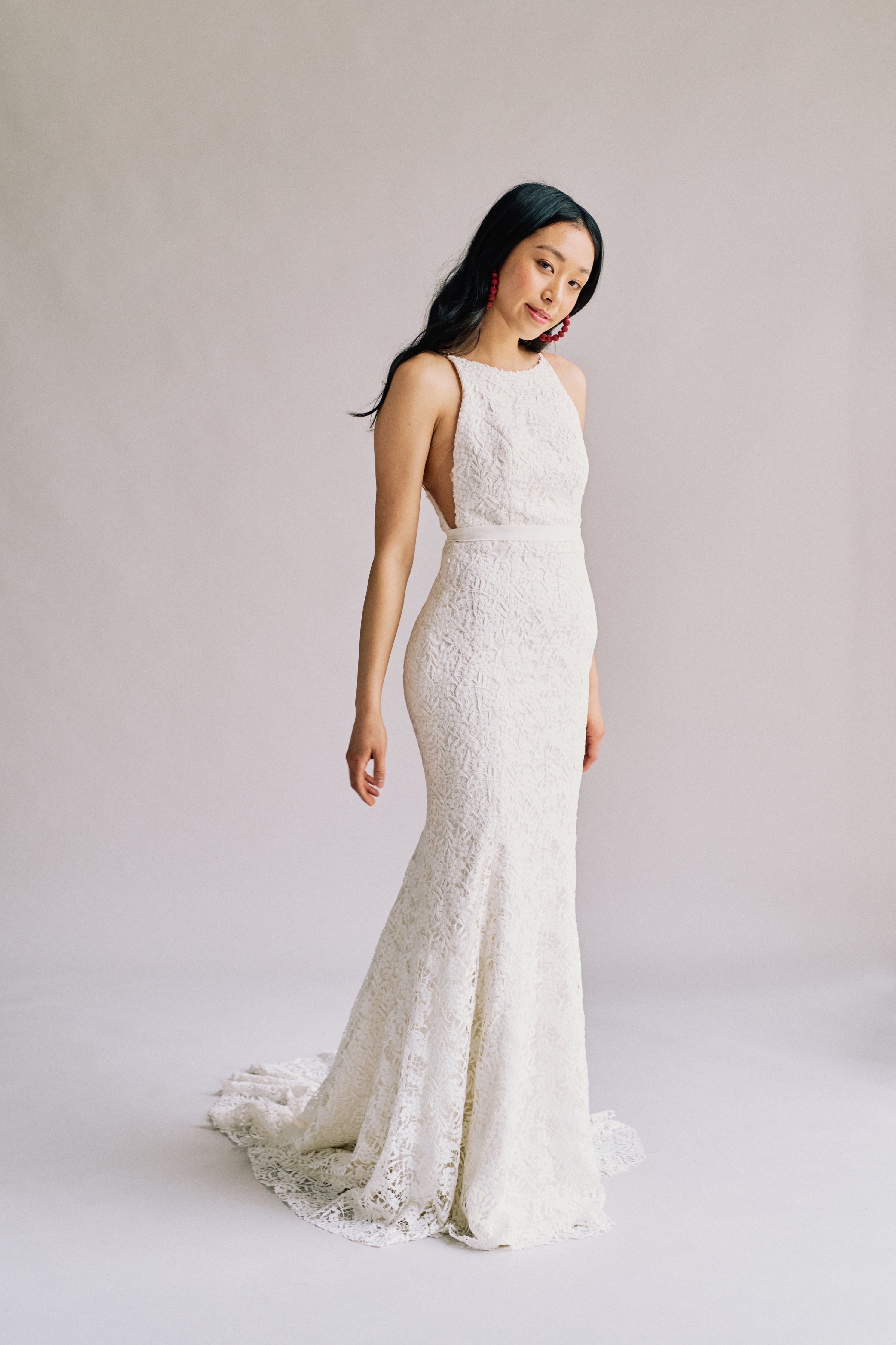 High neck low back form fitting wedding dress in full lace with a long train